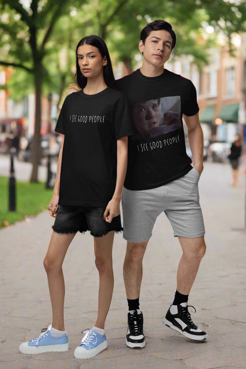 A mockup featuring a man and woman wearing matching oversized 'I See Good People' t-shirts made from garment-dyed fabric. The relaxed fit and minimalist white text design highlight the t-shirts' comfort and casual style, perfect for spreading positivity and good vibes.